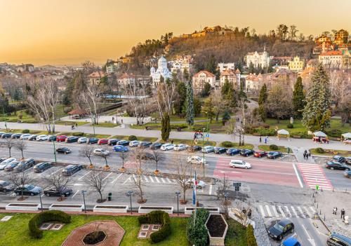 a city with cars parked in a parking lot at Hotel Aro Palace in Braşov