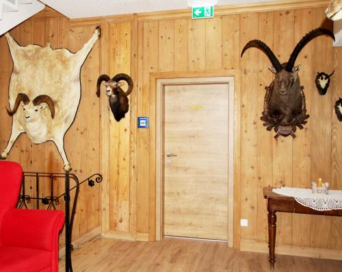 a room with wooden walls withanimal heads on the wall at Alpenhotel Ensmann in Göstling an der Ybbs
