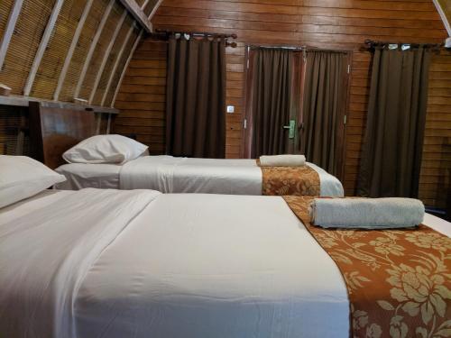 Habitación de hotel con 2 camas y cortinas en Paradesa Living, en Gili Trawangan