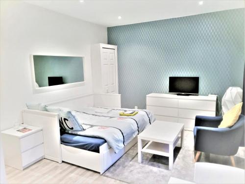Habitación blanca con cama, escritorio y silla en APPARTEMENT PROCHE CENTRE VILLE, GARE ET AUTOROUTE en Melun