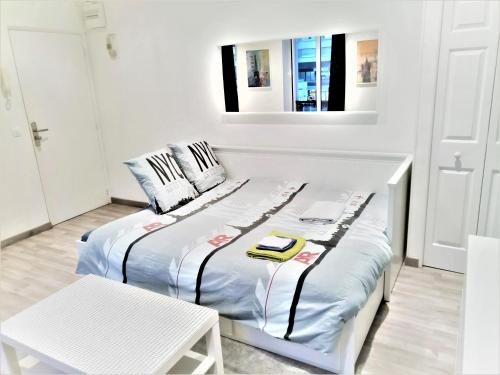 Habitación blanca con 2 camas y mesa en APPARTEMENT PROCHE CENTRE VILLE, GARE ET AUTOROUTE, en Melun