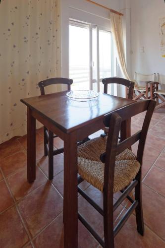 a wooden table and chairs in a room at PANORAMA in Pitsidia