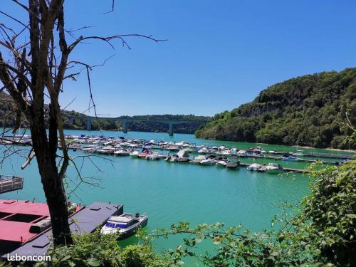 Un tas de bateaux sont amarrés dans une rivière dans l'établissement Charmant appartement dans maison de village, à Mesnois