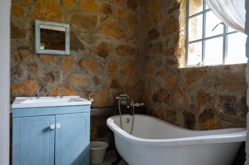 a bathroom with a bath tub and a sink at Kliphuis in Van Reenen