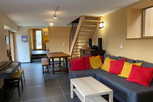 - un salon avec un canapé bleu et des oreillers rouges et jaunes dans l'établissement La Pellegrine, Parc national des Cévennes, à Le Salson