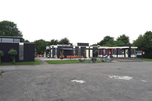 a parking lot with bikes parked in front of buildings at Chalet Bergen NH, Schoorl, Schoorldam in Warmenhuizen