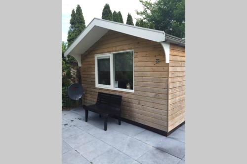 a shed with a bench in front of it at Chalet Bergen NH, Schoorl, Schoorldam in Warmenhuizen