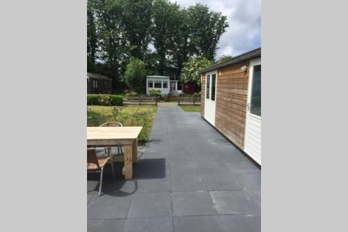 a patio with a table and a building at Chalet Bergen NH, Schoorl, Schoorldam in Warmenhuizen