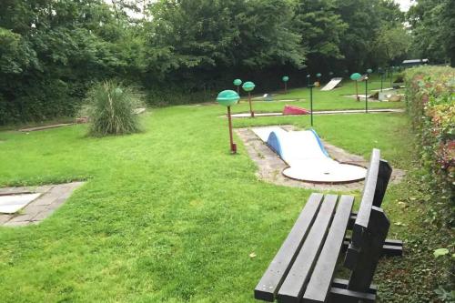 a park with a bench and a playground with a slide at Chalet Bergen NH, Schoorl, Schoorldam in Warmenhuizen