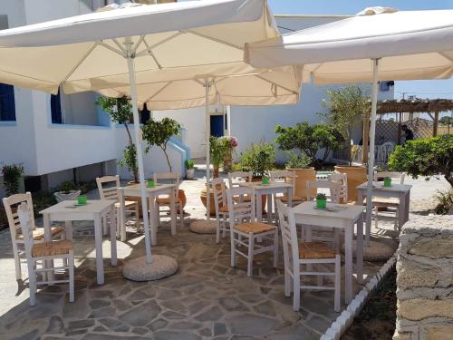 a group of tables and chairs under an umbrella at Aegean Sea in Lefkos Karpathou