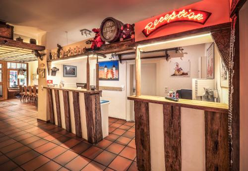 a restaurant with a counter with a restaurant sign on the wall at Hotel-Restaurant Hackteufel in Heidelberg