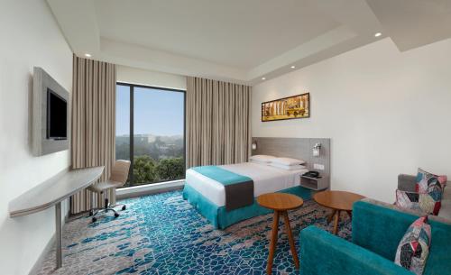 a hotel room with a bed and a couch at Holiday Inn Express Kolkata Airport by IHG in Kolkata
