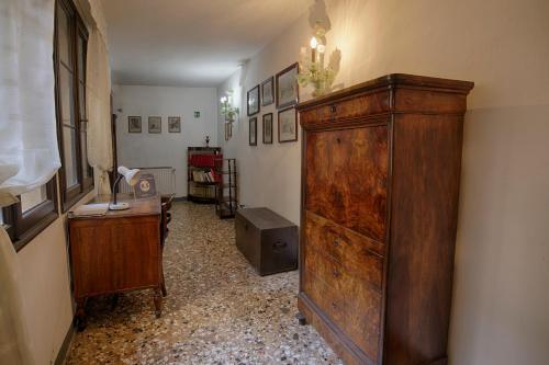ヴェネツィアにあるVintage Venice Apartmentの大きな木製キャビネットとデスクが備わる客室です。