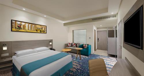 a hotel room with a bed and a flat screen tv at Holiday Inn Express Kolkata Airport by IHG in Kolkata
