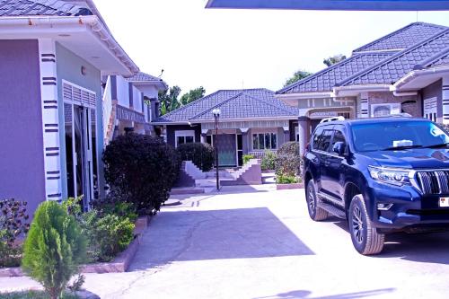 a blue truck parked in front of a row of houses at Bethel Resort & Hotels in Gulu