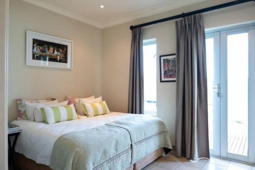 a bedroom with a bed and a large window at Highlands Farm House in Van Reenen