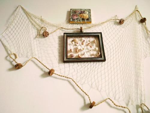 a picture frame hanging on a wall with a rope at Casa Poesia in Torre dell'Orso