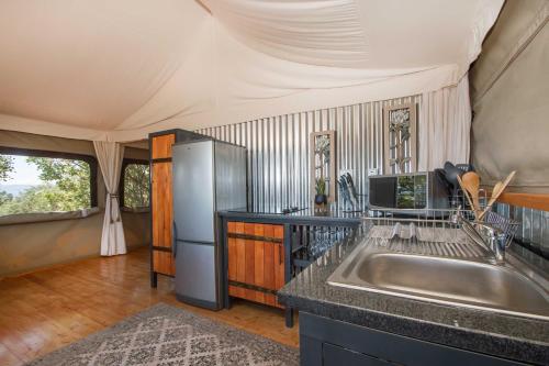 une cuisine avec un évier et un réfrigérateur dans l'établissement Idwala Le Ingwe Lodge, à Hekpoort