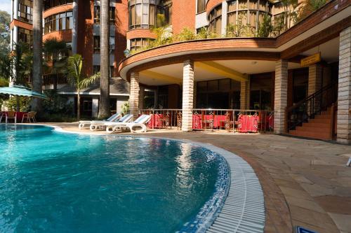 une piscine en face d'un bâtiment dans l'établissement Kibo Palace Hotel Arusha, à Arusha