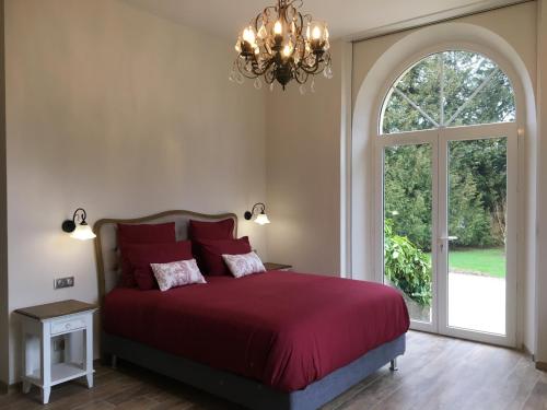 a bedroom with a red bed with a large window at Villa Bagatelle in Saint-Laurent-du-Pont