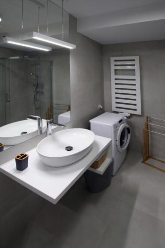 a bathroom with two sinks and a washing machine at LUX Apartament Rogowo Pearl in Rogowo