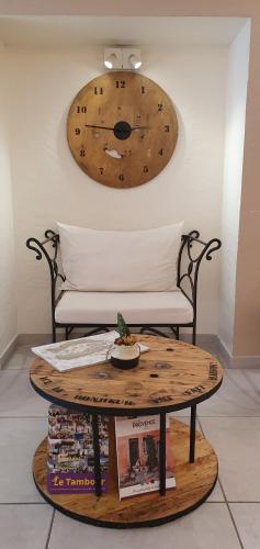 a wooden clock on the wall above a table at Le Mas Du Colombier in Cadenet