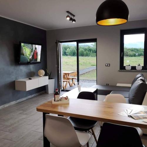 a living room with a dining room table and chairs at Apartamenty Malinówka pod Śnieżką in Kowary