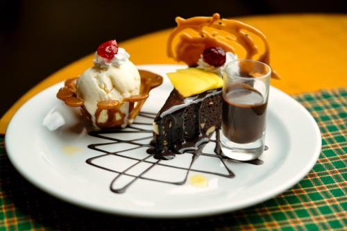 a plate of desserts on a table with a glass of coffee at Kibo Palace Hotel Arusha in Arusha