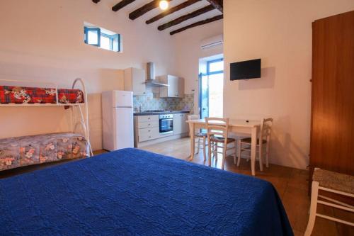 una camera con letto e una cucina con tavolo di Il Vulcano a Piedi a Stromboli