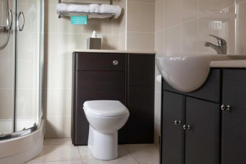 a bathroom with a white toilet and a sink at Clubhouse Cottage in Lacock