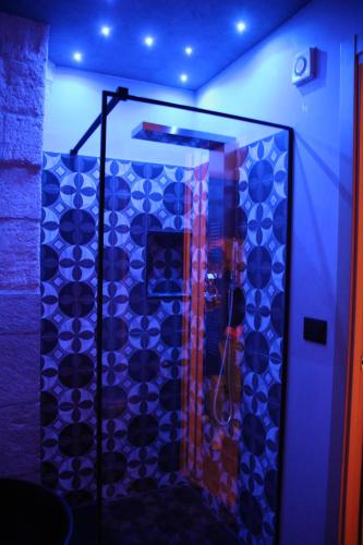 a bathroom with a glass shower with blue lights at La Dimora del Principe-Piano terra in Trani