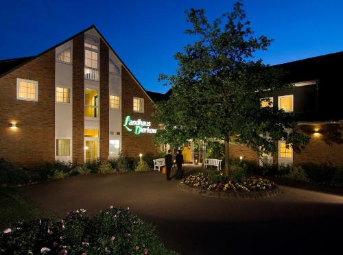 a person standing in front of a building at Hotel Landhaus Dierkow in Rostock
