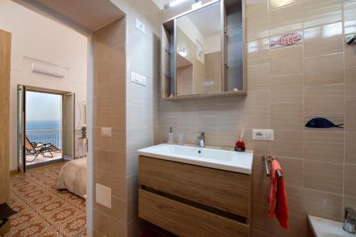 La salle de bains est pourvue d'un lavabo et d'un miroir. dans l'établissement Your home in the heart of Positano - centralissima, à Positano