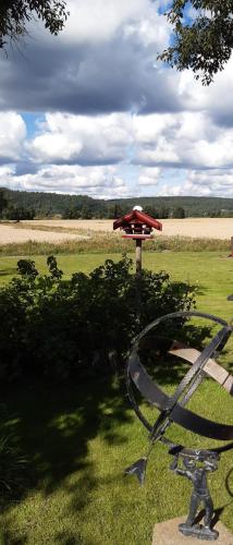 a statue in a field with a red umbrella at Gårdslägenhet nära Göteborg in Alvhem