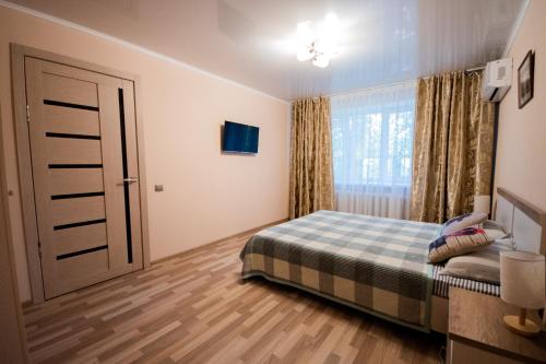 a bedroom with a bed and a window at Алтай 1-6, рядом с аэропортом in Almaty