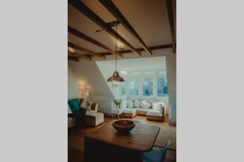 a living room with a couch and a table at Glide Surf Casa in Cromer