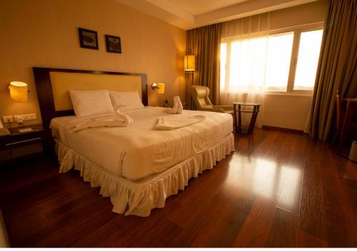 ein Schlafzimmer mit einem großen Bett und einem großen Fenster in der Unterkunft Grand Gardenia in Tiruchchirāppalli
