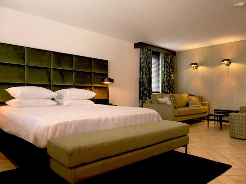 sypialnia z dużym łóżkiem i kanapą w obiekcie Hotel de Naaldhof w mieście Oss