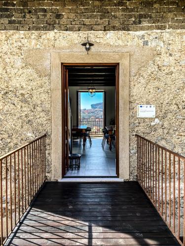 a door leading to a patio with a table and chairs at Tenuta Novecento Bioagriturismo in Agerola