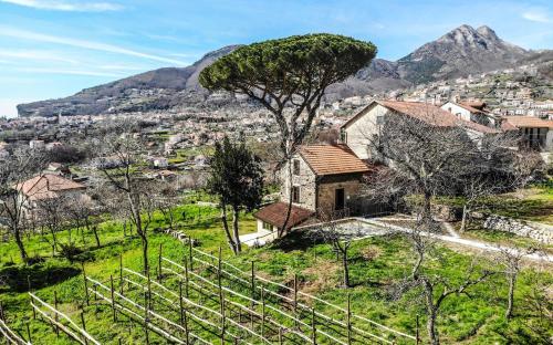 an old house on a hill with mountains in the background at Tenuta Novecento Bioagriturismo in Agerola
