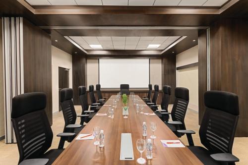 a large conference room with a long table and chairs at Ramada Encore by Wyndham Statue of Unity in Kevadia