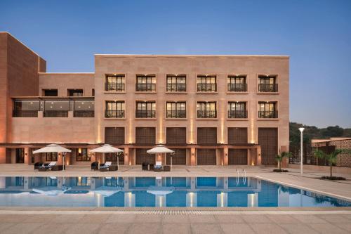 a building with a swimming pool in front of a building at Ramada Encore by Wyndham Statue of Unity in Kevadia