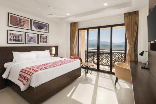 a hotel room with a bed and a balcony at Ramada Encore by Wyndham Statue of Unity in Kevadia