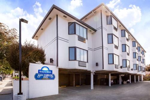 a large white building with a sign in front of it at Days Inn by Wyndham Monterey Downtown in Monterey