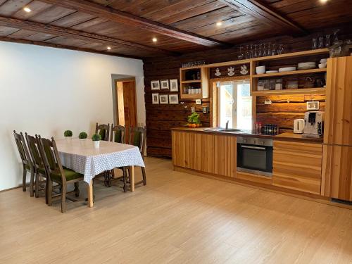 eine Küche mit einem Tisch und Stühlen sowie eine Küche mit Holzschränken in der Unterkunft Nurga Holiday Homes in Käina