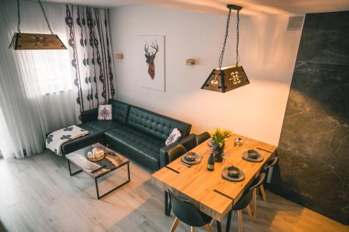 a living room with a green couch and a table at RelaxApart - Komfortowy apartament Pod Stokiem in Szczyrk