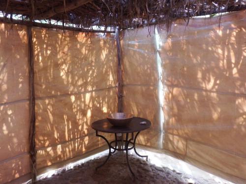 a small table in the corner of a wall at Dar Paru in Mhamid