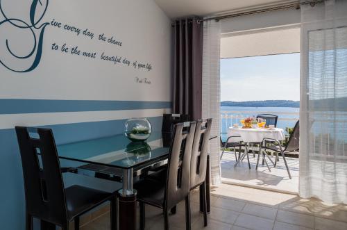 a dining room with a table and chairs and a balcony at Adriatic Sea View Apartments in Trogir