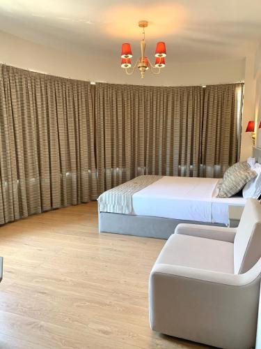 a bedroom with a bed and a chair and a couch at Illyrian Boutique Hotel in Sarandë