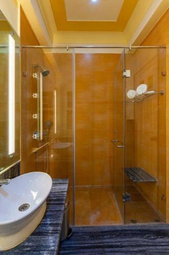 a bathroom with a glass shower and a sink at Anand Bagh Resort & Spa by Ananta in Sālāsar